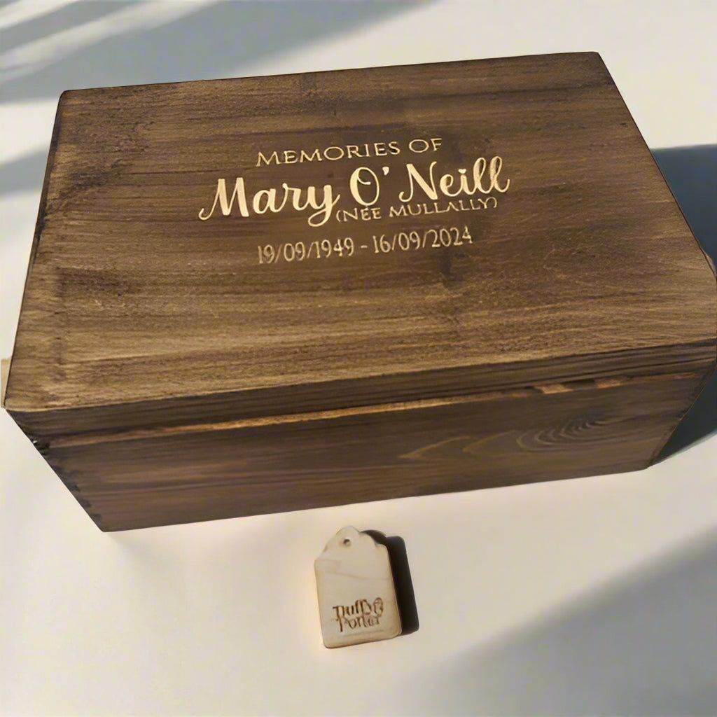Wooden box with engraved text on a wooden surface