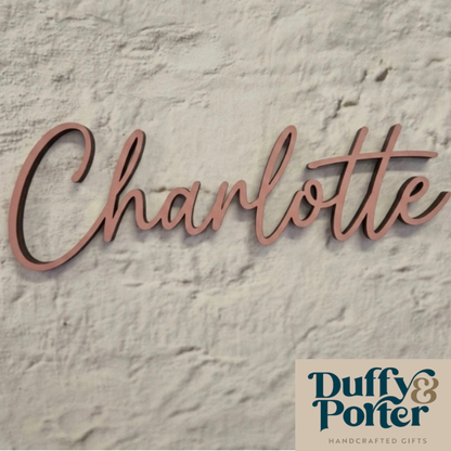 Wooden name sign 'Charlotte' on a textured stone background with Duffy & Porter branding.