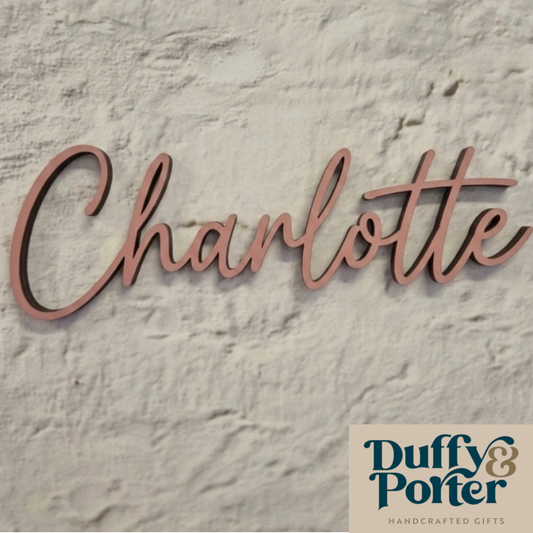Wooden name sign 'Charlotte' on a textured stone background with Duffy & Porter branding.