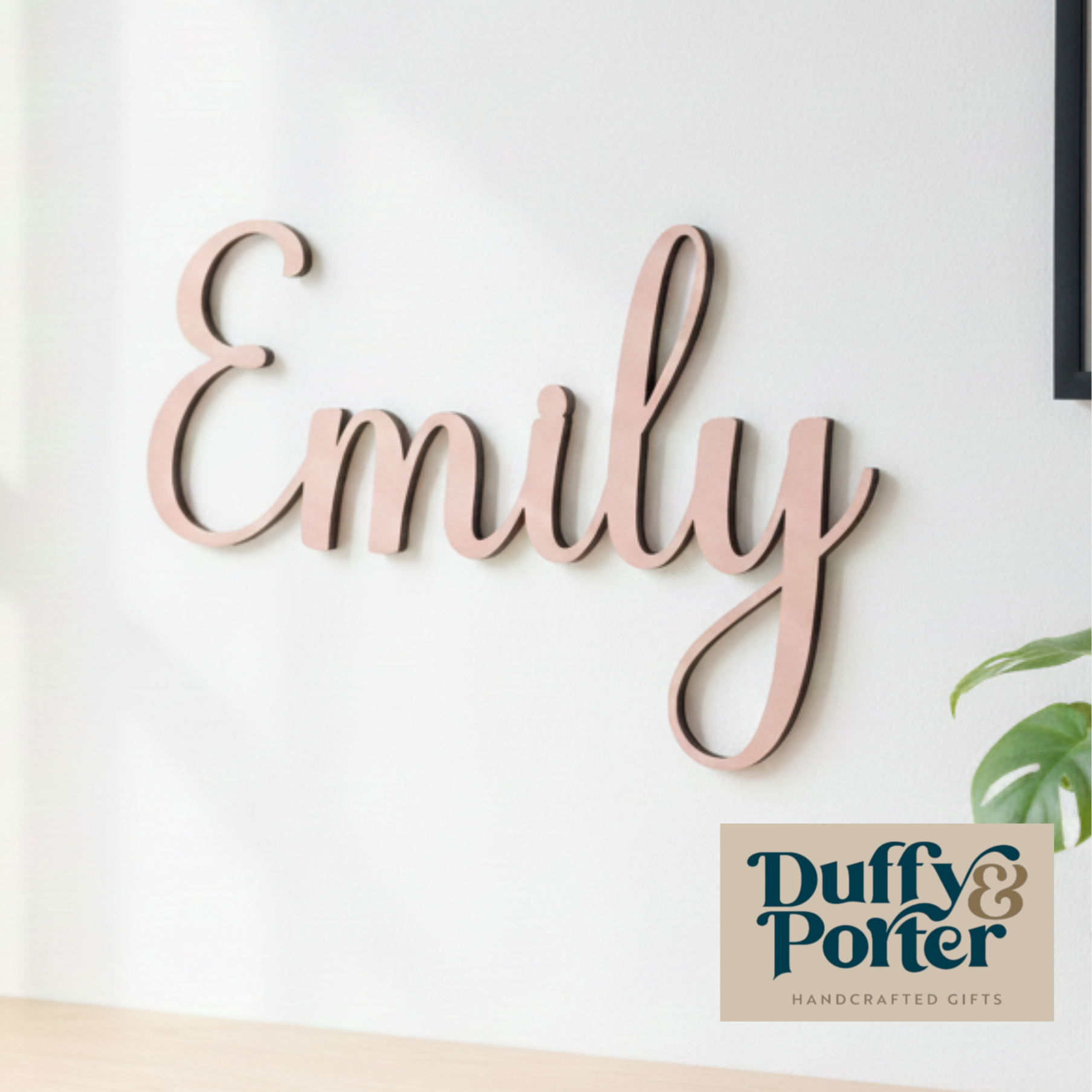 Wooden name sign spelling 'Emily' on a white wall with Duffy & Porter branding.