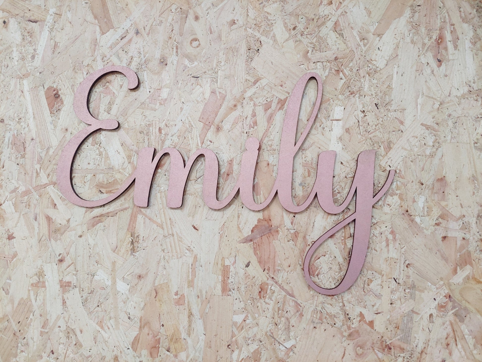 Pink wooden name 'Emily' on a textured beige background